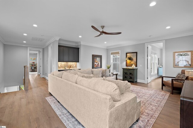 living room with hardwood / wood-style flooring and crown molding