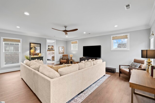 living room featuring ornamental molding, ceiling fan, and light hardwood / wood-style flooring