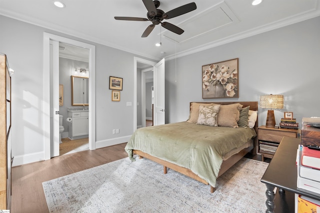 bedroom with light wood-type flooring, crown molding, ceiling fan, and ensuite bath