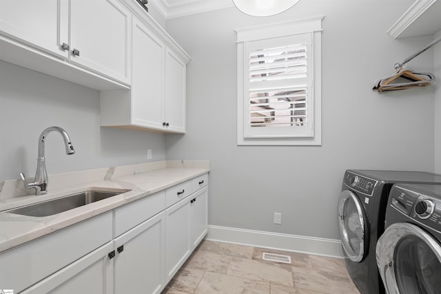 laundry room featuring independent washer and dryer, cabinets, sink, and ornamental molding