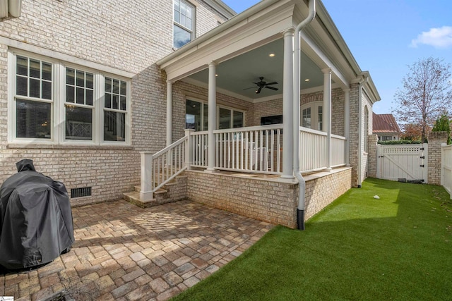 exterior space with ceiling fan, a lawn, and a patio area