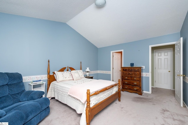 bedroom featuring vaulted ceiling, light carpet, and a textured ceiling