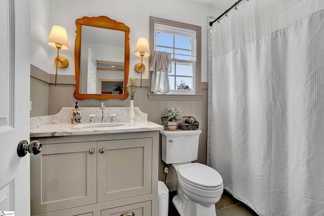 bathroom featuring tile patterned flooring, vanity, toilet, and walk in shower