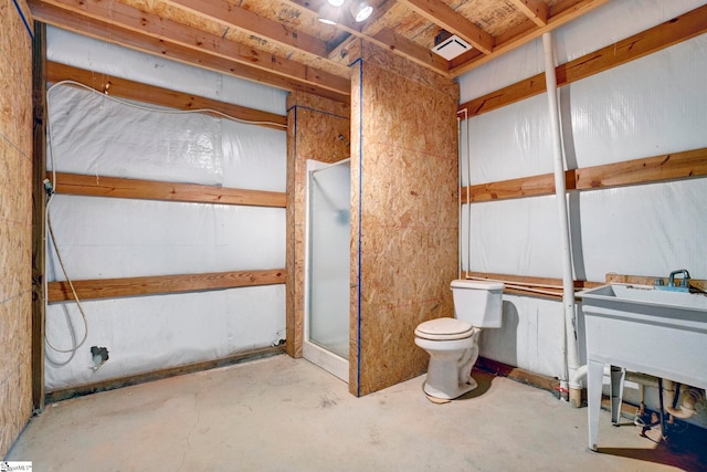 bathroom featuring a shower, concrete floors, and toilet