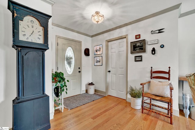 foyer entrance featuring crown molding and hardwood / wood-style floors