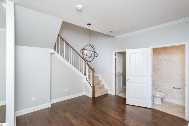 interior space with dark wood-type flooring, ornamental molding, and an inviting chandelier