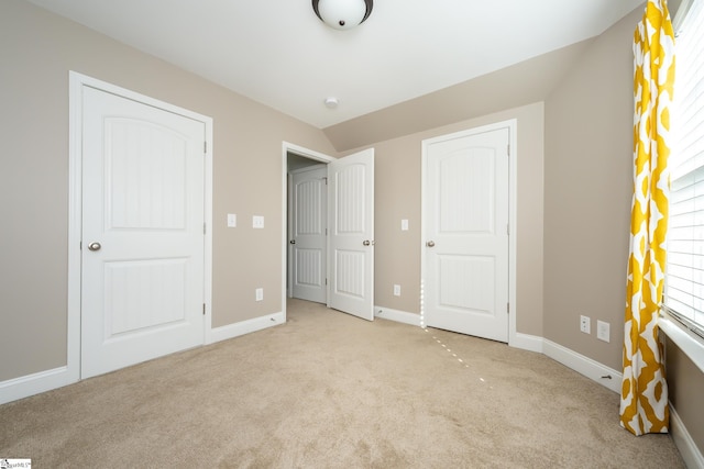 unfurnished bedroom featuring multiple windows and light colored carpet