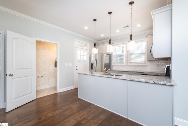 kitchen featuring sink, light stone countertops, decorative light fixtures, appliances with stainless steel finishes, and dark hardwood / wood-style flooring