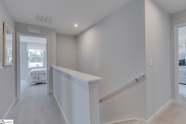 hallway with light colored carpet