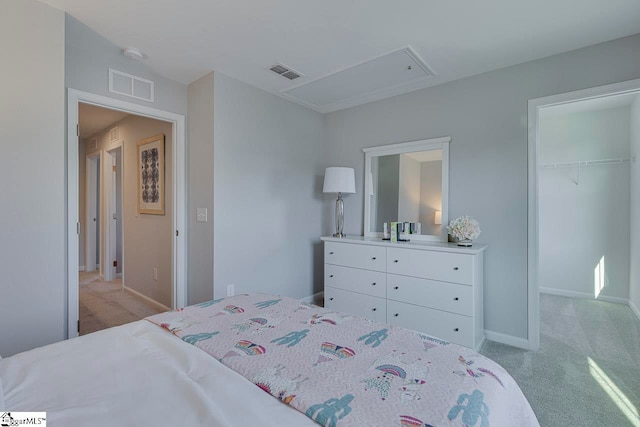 bedroom featuring a closet, light carpet, and a walk in closet