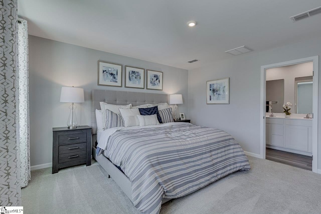 carpeted bedroom featuring ensuite bath