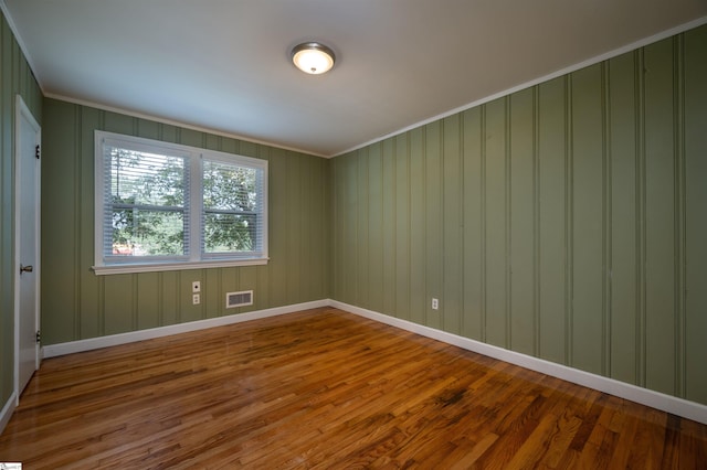 unfurnished room with crown molding and hardwood / wood-style floors