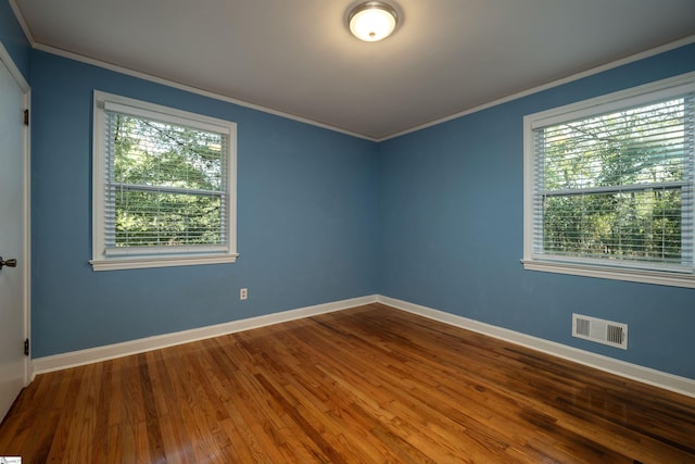 spare room with crown molding and hardwood / wood-style flooring