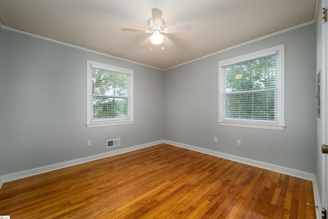 spare room featuring ornamental molding, a healthy amount of sunlight, hardwood / wood-style flooring, and ceiling fan