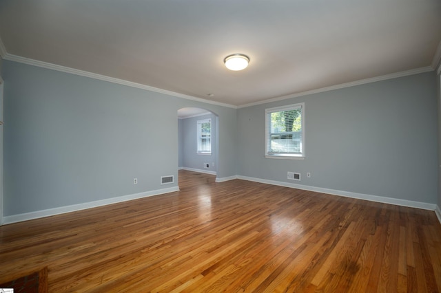 empty room featuring ornamental molding and hardwood / wood-style floors