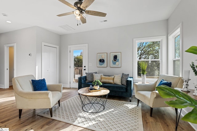 living room featuring light hardwood / wood-style flooring and ceiling fan