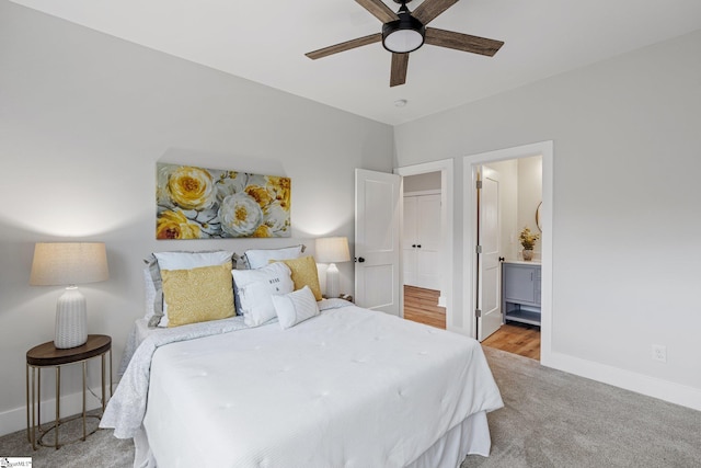 bedroom featuring ensuite bath, light colored carpet, and ceiling fan