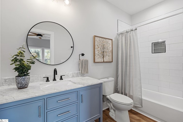 full bathroom featuring shower / bathtub combination with curtain, toilet, hardwood / wood-style floors, vanity, and ceiling fan