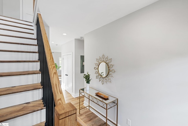 stairs with electric panel and wood-type flooring