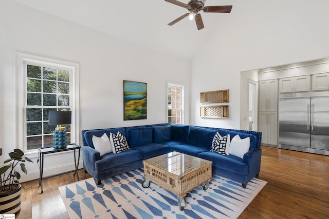 living room with high vaulted ceiling, wood-type flooring, a healthy amount of sunlight, and ceiling fan