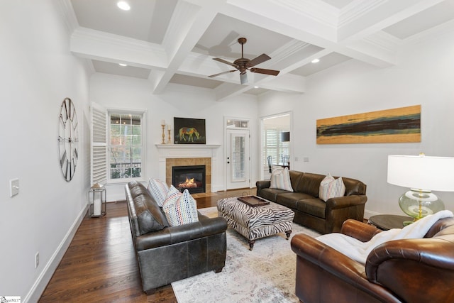 living room with coffered ceiling, beam ceiling, a tile fireplace, dark hardwood / wood-style flooring, and ceiling fan