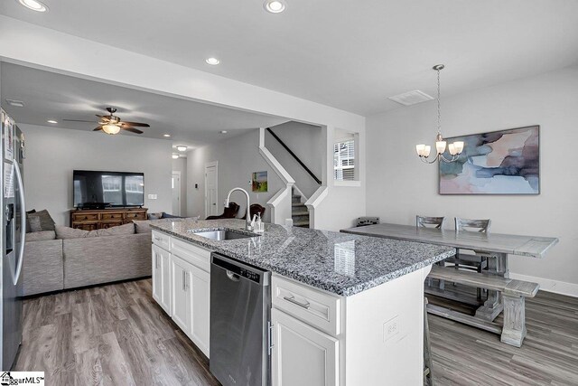 kitchen with white cabinets, an island with sink, stainless steel dishwasher, wood-type flooring, and sink