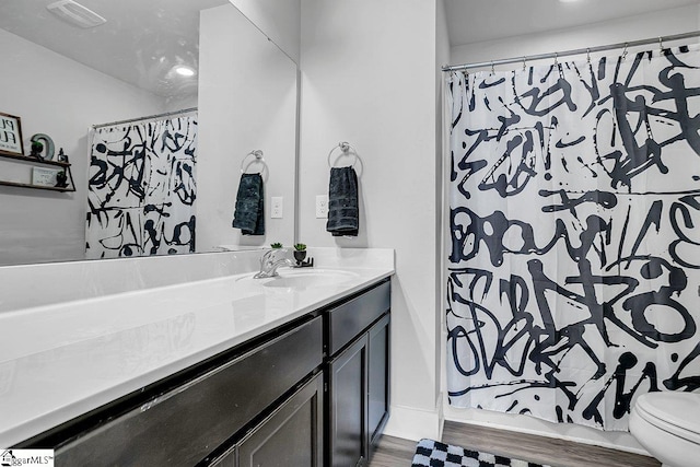 bathroom featuring vanity, a shower with shower curtain, hardwood / wood-style flooring, and toilet