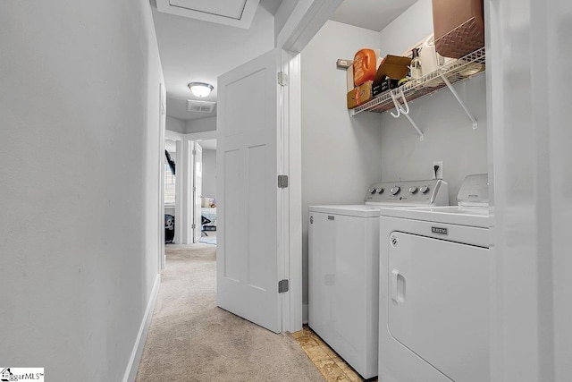 laundry room featuring washing machine and dryer and light colored carpet