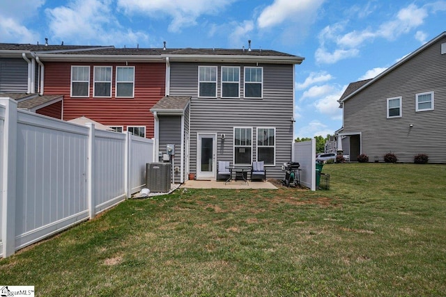 rear view of house with central AC, a patio area, and a lawn