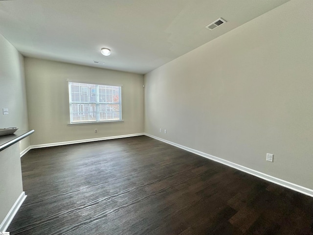 spare room with dark wood-type flooring