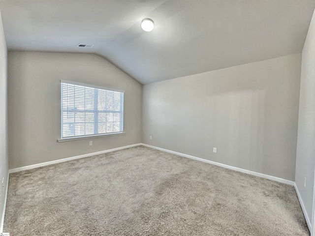 unfurnished room with carpet and vaulted ceiling