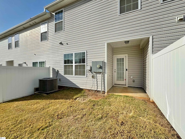 back of house with a patio area, a lawn, and central AC unit