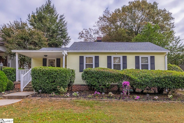 view of front of house with covered porch and a front lawn