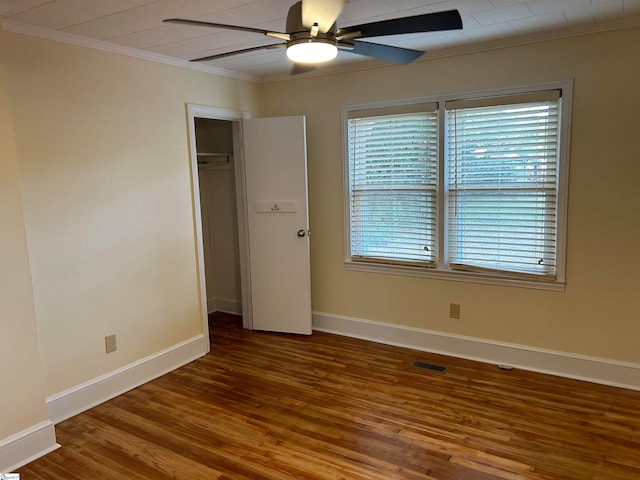 unfurnished bedroom with a closet, ceiling fan, hardwood / wood-style flooring, and ornamental molding