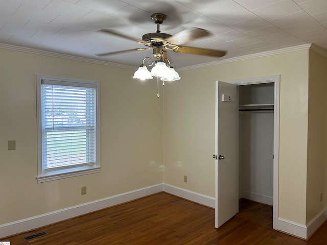 unfurnished bedroom with ornamental molding, dark hardwood / wood-style floors, a closet, and ceiling fan