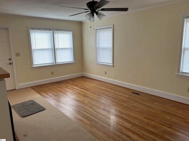 spare room with ornamental molding, light wood-type flooring, and ceiling fan