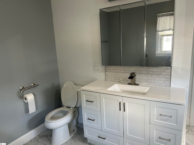 bathroom with vanity, toilet, and backsplash