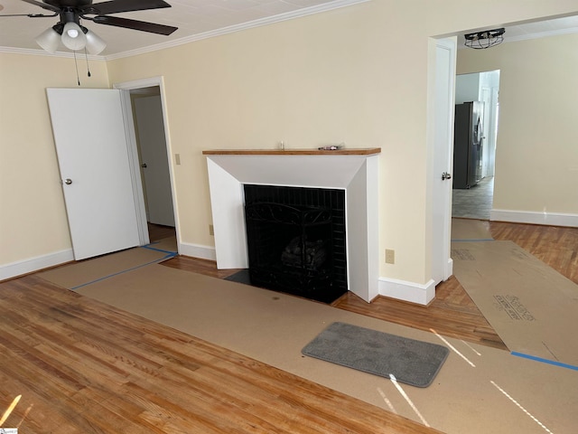 unfurnished living room featuring crown molding, hardwood / wood-style floors, and ceiling fan