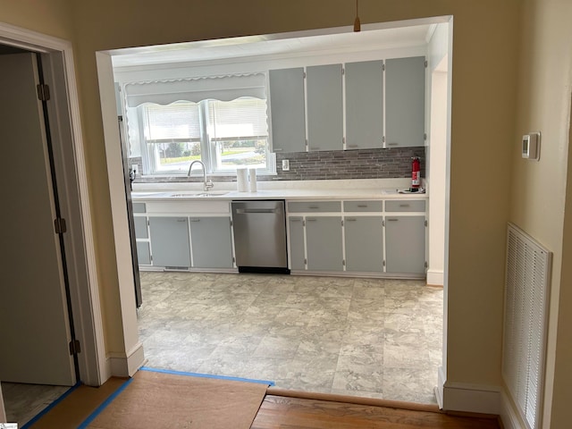 kitchen featuring gray cabinets, sink, dishwasher, and decorative backsplash