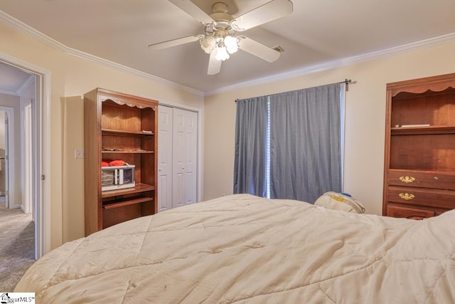 carpeted bedroom featuring crown molding, a closet, and ceiling fan