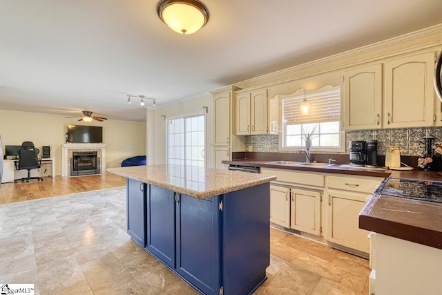 kitchen with sink, decorative backsplash, cream cabinetry, and ceiling fan