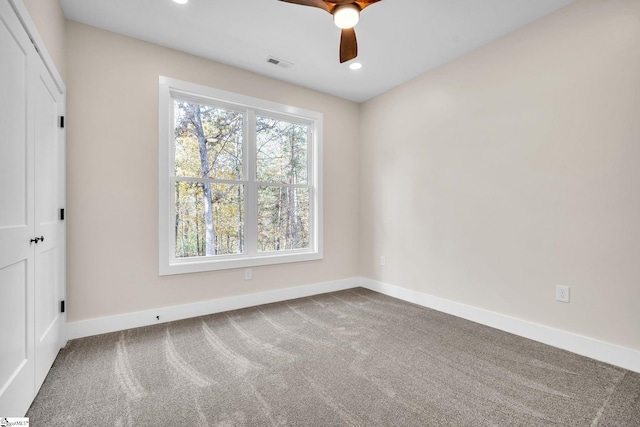 carpeted spare room featuring ceiling fan