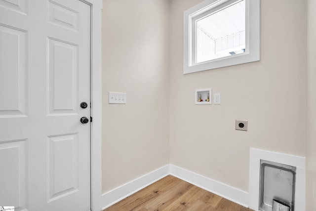 clothes washing area with electric dryer hookup, washer hookup, and light hardwood / wood-style floors