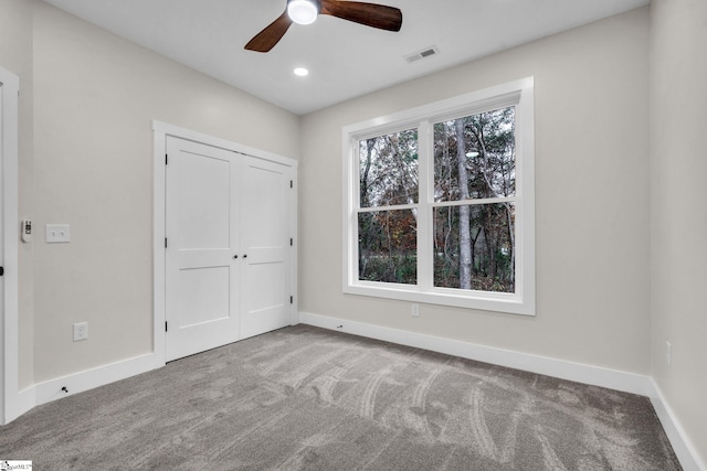 unfurnished bedroom featuring baseboards, visible vents, and carpet
