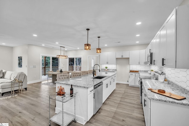 kitchen with stainless steel appliances, recessed lighting, a sink, and light wood-style floors