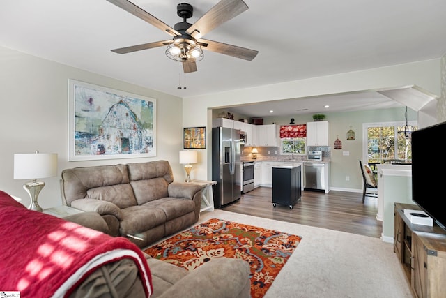 living room featuring ceiling fan, sink, and dark hardwood / wood-style flooring