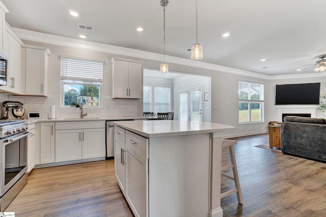 kitchen with a wealth of natural light, sink, appliances with stainless steel finishes, and white cabinets