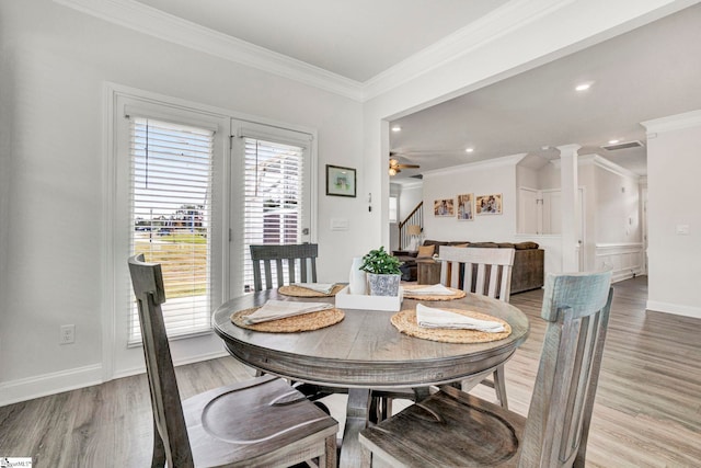 dining space featuring ceiling fan, crown molding, decorative columns, and light wood-type flooring