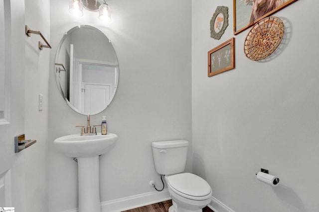 bathroom with toilet and hardwood / wood-style flooring