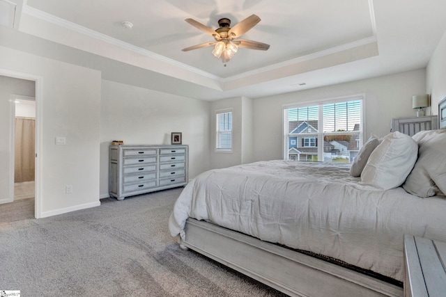 bedroom featuring crown molding, a raised ceiling, light carpet, and ceiling fan